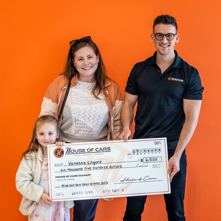 A 2022 Wipe Out Your Debt winner and her daughter with a House of Cars cheque for six thousand five hundred dollars.