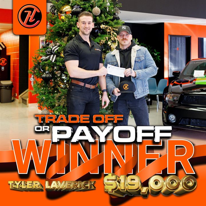 A House of Cars Trade Off or Payoff winner receiving a cheque for nineteen thousand dollars in the dealership showroom.